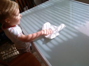 toddler boy wiping down kitchen table
