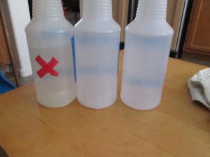 Back of spray bottles showing that the bleach bottle has a red x on the back too