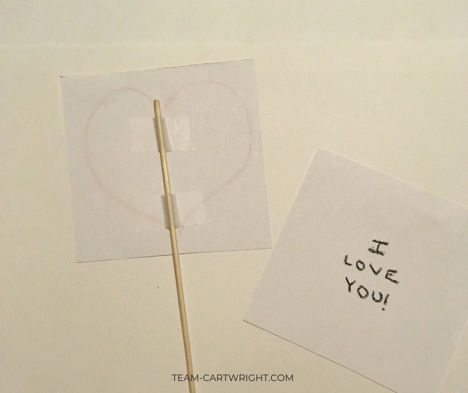 Thaumatropes for kids Step 2: Tape the skewer into place! #Thaumatrope #ValentineCard #ValentineSTEM #HomemadeValentine Team-Cartwright.com