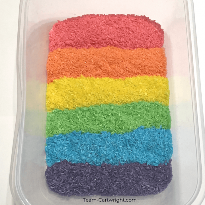 Colored rice for rainbow sensory play! Learn how easy it is to make this colorful sensory bin and get even more sensory activity ideas. #SensoryPlay #SensoryBin #ColoredRice #RainbowRice #RainbowSensory Team-Cartwright.com