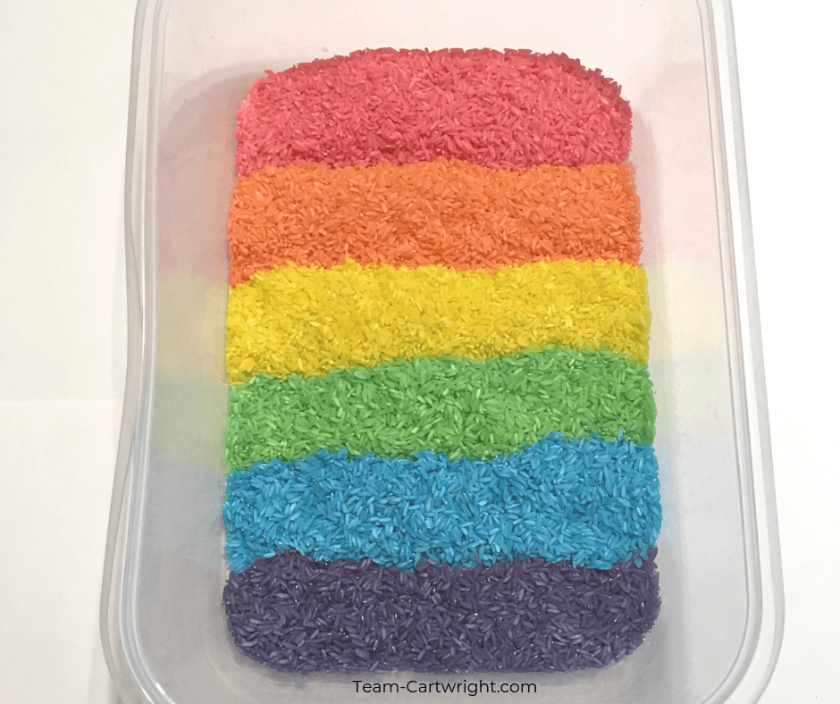 Colored rice for rainbow sensory play! Learn how easy it is to make this colorful sensory bin and get even more sensory activity ideas. #SensoryPlay #SensoryBin #ColoredRice #RainbowRice #RainbowSensory Team-Cartwright.com