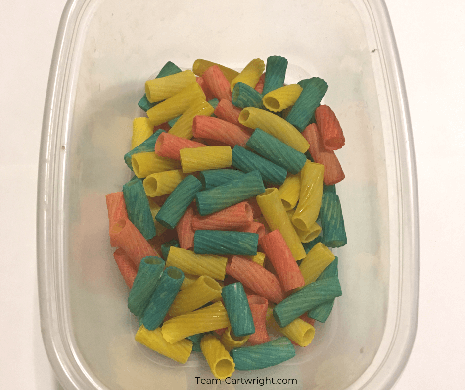 Make easy and fun rainbow sensory bins for your toddler or preschooler! Learn how to put together a fast and fun sensory learning activity, including dying pasta and rice! #SensoryBin #SensoryActivity #SensoryPlay #LearningActivity #RainbowActivity #RainbowBin Team-Cartwright.com