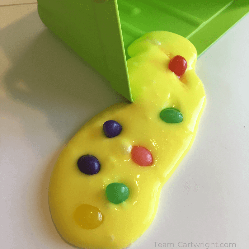 picture of yellow jelly bean slime with multi colored jelly beans coming out of a green easter basket