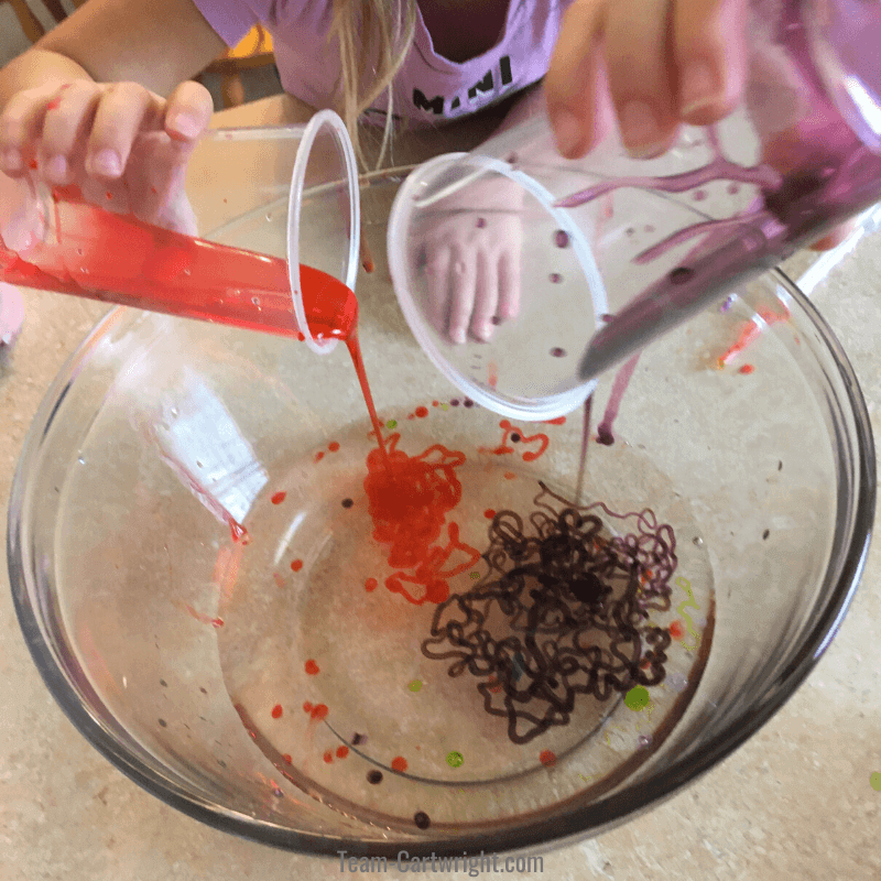 picture of children mixing solutions to make slime worms