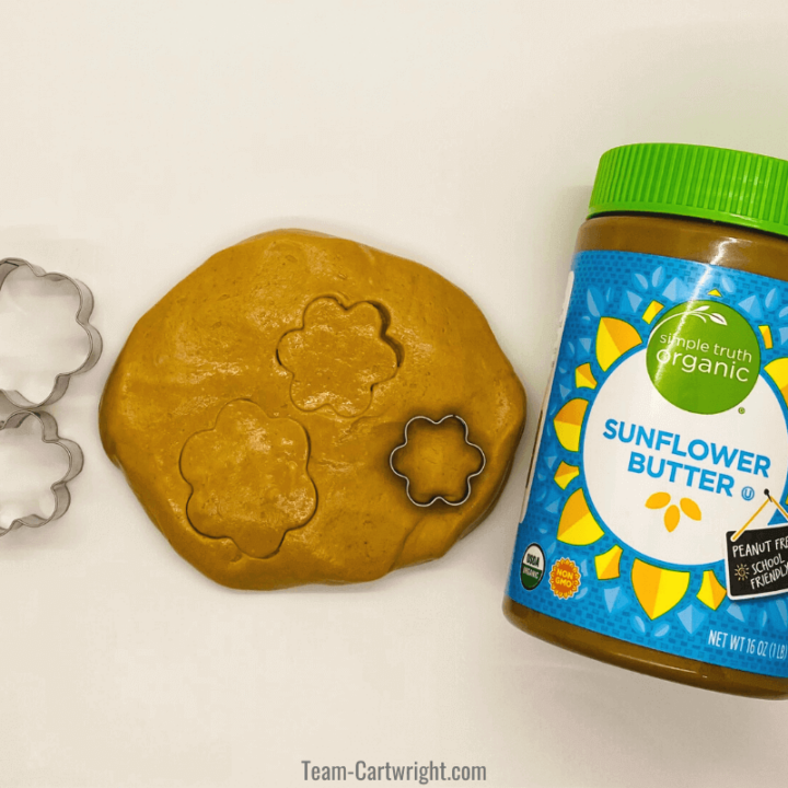 edible sunbutter playdough with 3 flower cookie cutters and jar of sunflower seed butter